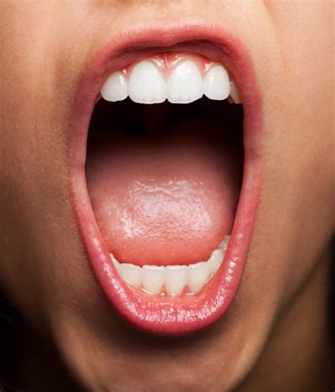 Close-up of young woman showing her teeth and tongue Photo ...