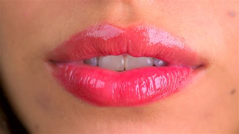 Extreme close up of lips blowing a kiss and smiling ...