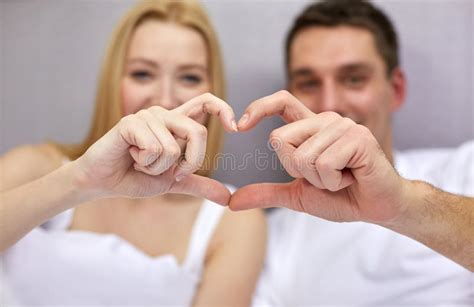 Smiling Couple In Bed Making Heart Shape Gesture Stock ...