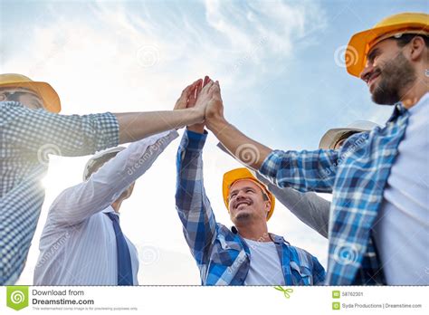 Close Up Of Builders In Hardhats Making High Five Stock ...